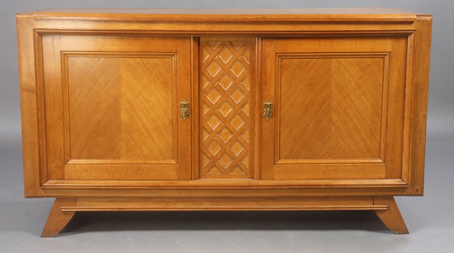 MID CENTURY MODERY OAK SIDEBOARD TWO DOORS: A modern oak sideboard having a central diamond pattern panel flanked by two bookmatched paneled doors circa 1940. The whole resting on short splayed legs. Ht: 38" Width: 67" Depth: 24"
