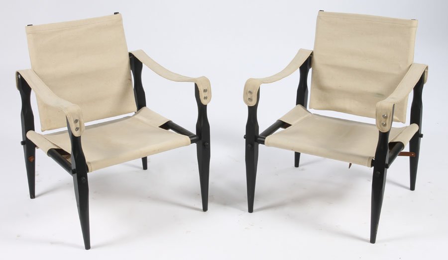 PAIR FRENCH CAMPAIGN ARM CHAIRS CANVAS BACKS: A pair of French campaign style arm chairs having canvas backs and seats with ebonized wood collapsable frames circa 1950. Ht: 30" Width: 24" Depth: 24"