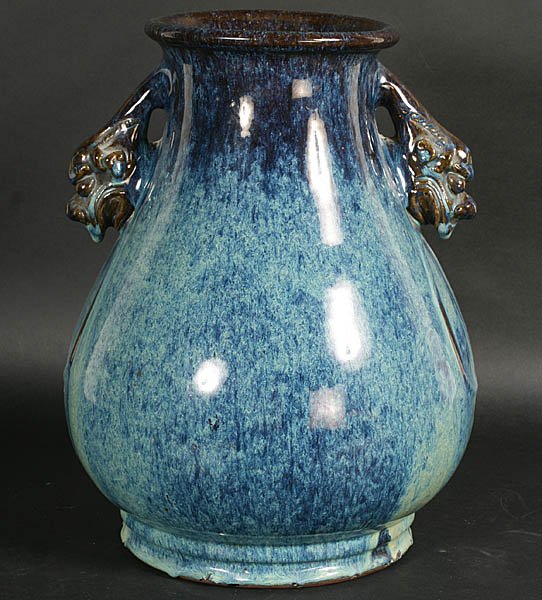 ANTIQUE CHINESE STONEWARE FOO DOG STONEWARE VASE: Handsome Chinese stoneware vase with Deco style foo dog head handles circa 1900. Glaze copied by the Belgians and Fulper among others in the Art Pottery period. Ht: 14.5" Width: 12" Depth: 12"