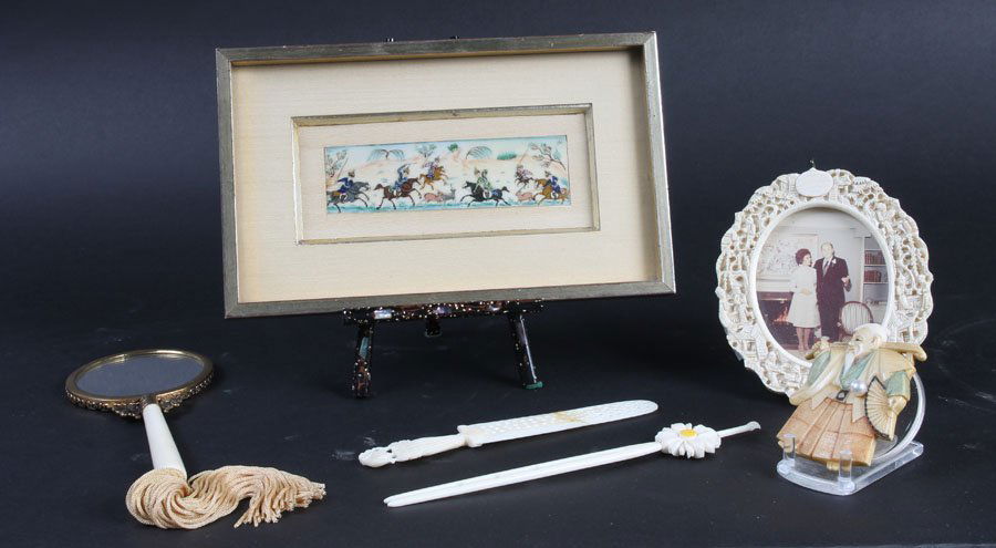 LOT OF IVORY DESKTOP ITEMS: Lot of ivory dresser and decorative items. Oval picture frame: 4.5"H. Framed Thai painted ivory hunting scene: 5.5" x 9". Carved pin with pearl: 2.75". Mirror: 7". Daisy top tool: 7". Bookmark (repair