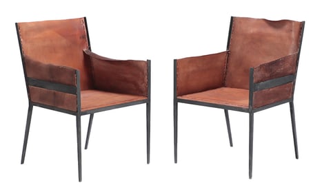 PAIR OF TAILORED IRON AND LEATHER ARM CHAIRS IN THE MANNER OF JEAN-MICHEL FRANK.