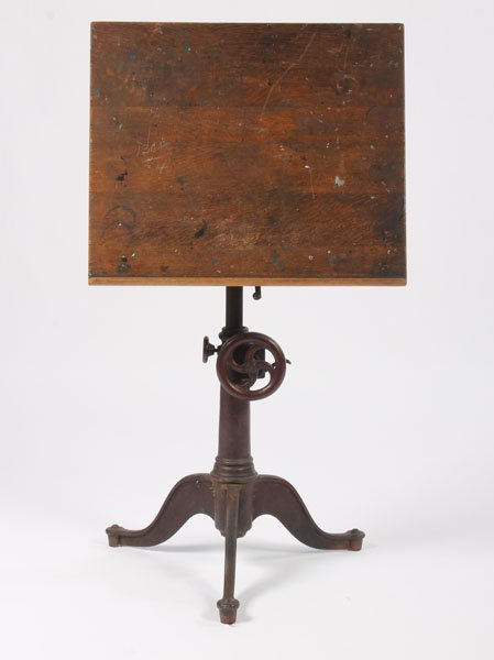 ANTIQUE IRON MECHANICAL OAK TOP DRAFTING TABLE: Turn of the century cast iron mechanical drafting table having a oak top over and adjustable iron base circa 1900. Ht: 40" Width: 26" Depth: 22"