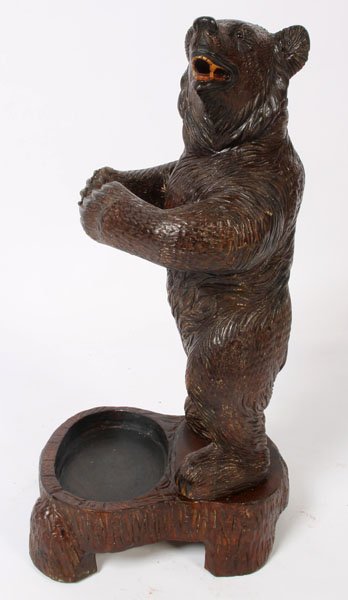 BLACK FOREST CARVED WOOD UMBRELLA STAND BEAR: A Black Forest carved wood umbrella stand in the form of a bear with outstretched arms, having glass eyes. Ht: 34" Width: 14" Depth: 17"