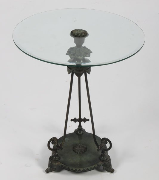 ART DECO STYLE BRONZE SIDE TABLE BEVELED GLASS: An Art Deco style bronze side table having beveled glass top supported on three reeded scrolling legs with round platform base and stylized paw feet. Ht: 25" Dia: 20"