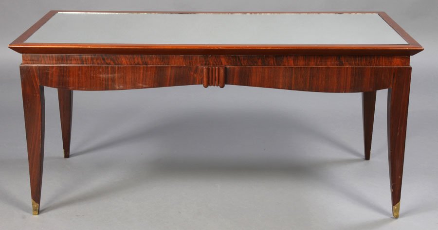 JULES LELEU STYLE MAHOGANY COFFEE TABLE C.1930: A Jules Leleu style mahogany coffee table with inset mirror resting on shaped top and tapered legs with bronze soabots circa 1930. Ht: 20" Width: 43.5" Depth: 20"