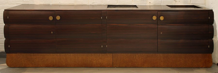 ART DECO MACASSAR SIDEBOARD GLASS BURLED MAPLE: An Art Deco macassar sideboard having two inset glass sliding compartments over four fluted front doors supported on burled maple legs circa 1940. Ht: 32.5" Width: 106" Depth: 22"