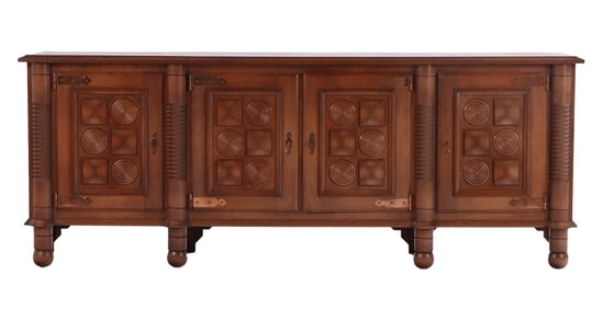 ONE OF TWO FRENCH OAK FOUR DOOR SIDEBOARDS IN THE MANNER OF CHARLES DUDOUYT C 1940. THE CASE HAVING