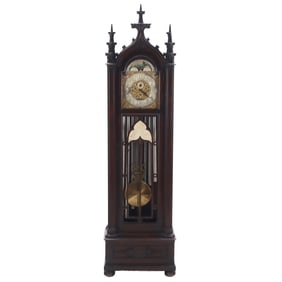 A GOTHIC STYLE CARVED MAHOGANY TALL CASE CLOCK HAVING NINE TUBES.