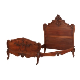 FRENCH CARVED WALNUT BED HAVING A CHERUB CARVED CREST, CARVED FOOTBOARD AND CARVED RAILS  1890.