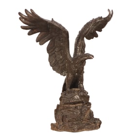 LARGE CAST BRASS GARDEN SCULPTURE DEPICTING AN EAGLE WITH SPREAD WINGS STANDING ON A ROCK.