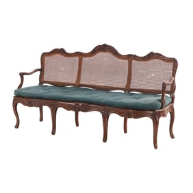 A NINETEENTH CENTURY CONTINENTAL OPEN ARM SOFA HAVING A CANE BACK AND SEAT WITH LOOSE CUSHION.