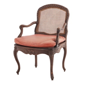 NINETEENTH CENTURY CONTINENTAL CARVED OPEN ARM CHAIR HAVING A CANE SEAT AND BACK.