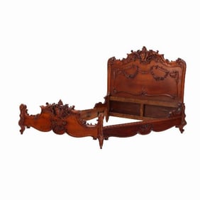 A highly ornate French Louis XV style carved mahogany queen size bed C 1900.