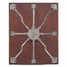 Antique steel lock mechanism mounted on a wooden board.