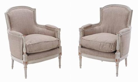 A pair of Louis XVI style painted and gilt bergere chairs C 1950.