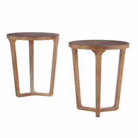 A tall pair of round parchment covered end tables .