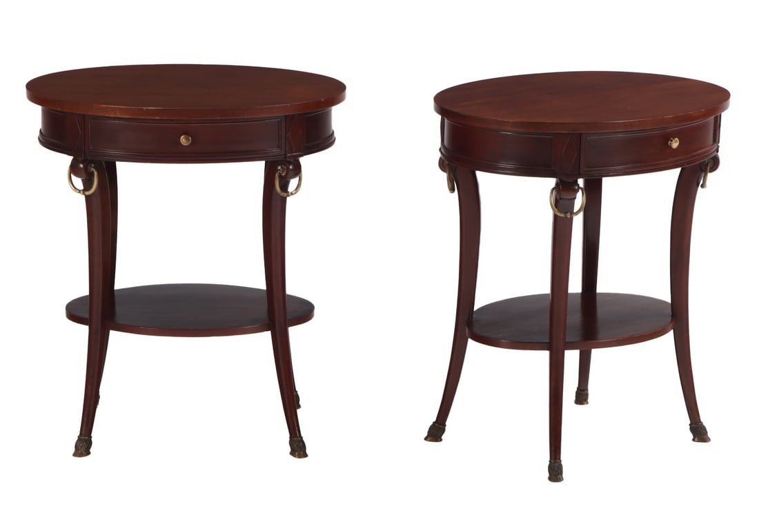 PAIR OVAL MAHOGANY END TABLES EACH HAVING A SINGLE DRAWER C 1950 WITH BRONZE RING DETAILS AND BRONZE: Pair oval mahogany end tables each having a single drawer C 1950 with bronze ring details and bronze hooved feet attributed to Jansen. Ht: 25.75" Wd: 23" Dpth: 18.25"