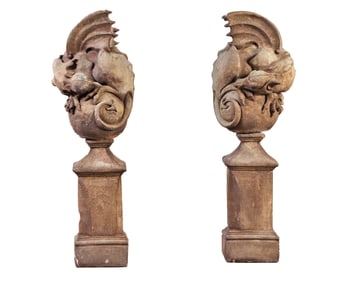 PAIR OF SANDSTONE WINGED GARGOYLES WRAPPED AROUND SPHERES AND RESTING ON A SEPERATE BASE.
