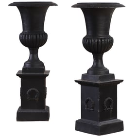 49" PAIR OF CAST IRON CAMPAGNA FORM GARDEN URNS ON SEPARATE WREATH DECORATED CAST IRON BASE.