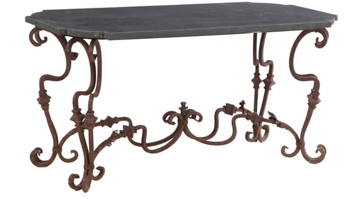 FRENCH HEAVY CAST IRON GARDEN TABLE WITH SCROLL FORM LEGS AND HAVING A BLUE STONE TOP WITH SHAPED