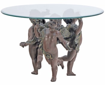 A BRONZE AND GLASS DANCING CHERUB COFFEE TABLE.