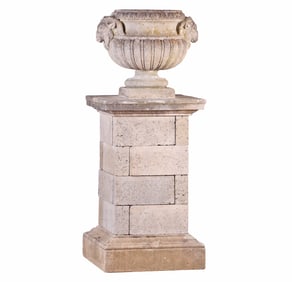 LIMESTONE GARDEN URN WITH RAM HEADS MOUNTS C 1920 RESTING ON A BASE HAVING A LIMESTONE TOP AND