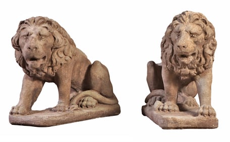 PAIR CAST STONE CROUCHED LIONS.