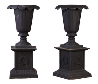 A PAIR OF PAINTED CAST IRON VASE FORM GARDEN URNS ON SEPARATE PEDESTALS..