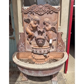 CARVED MARBLE WALL FOUNTAIN HAVING WINGED PUTTI AND LION MASK DECORATION. BREAKS DOWN FOR
