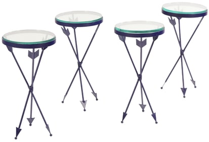 A SET OF FOUR BLACK IRON AND GLASS DRINKS TABLES HAVING ARROW FORM LEGS.