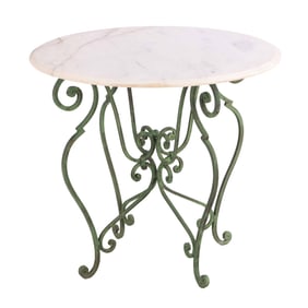 A MARBLE TOP TABLE HAVING ELABORATE WROUGHT IRON BASE.
