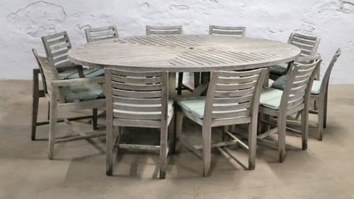 A LARGE TEAK GARDEN OR DECK TABLE WITH TEN MATCHING CHAIRS WITH SEAT CUSHIONS.