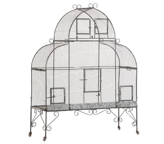 A MONUMENTAL VINTAGE IRON FRENCH BIRD CAGE RAISED ON SCROLL FORM DECORATED BASE WITH CASTERS.