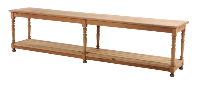A MONUMENTAL PINE DRAPERS TABLE HAVING TURNED LEGS AND BUN FEET C 1890.