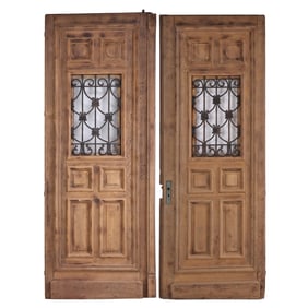 ONE OF TWO PAIR OF FRENCH CARVED OAK DOORS HAVING RAISED PANELS AND WROUGHT IRON SIGHT PANELS CIRCA
