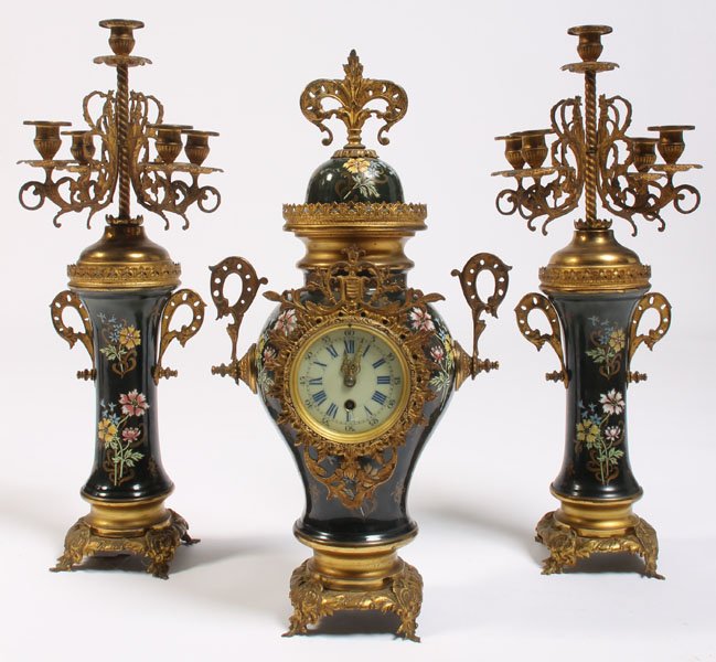 3 PC BRONZE PAINTED PORCELAIN GARNITURE CLOCK SET: A three-piece bronze and painted porcelain garniture clock set. The candelabra measure 24" and the clock measures 22".