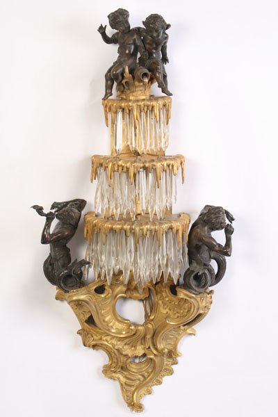 A ROCOCO REVIVIAL BRONZE SCONCE W/ PUTTI C. 1910: A magnificent Rococo revival dore and natural bronze sconce depicting two putti atop cascading fountains circa 1910. Ht: 43" Width: 19" Depth: 9"