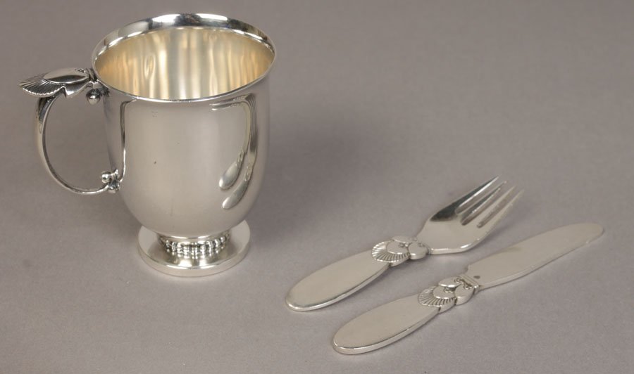 3 PC GEORGE JENSEN CACTUS PATTERN BABY SET: Three piece George Jensen cactus pattern baby set circa 1950. Consisting of a baby knife and fork measuring 4.25" x 3.25" and a 3" cup. Total weight is 5.27 troy ounces.
