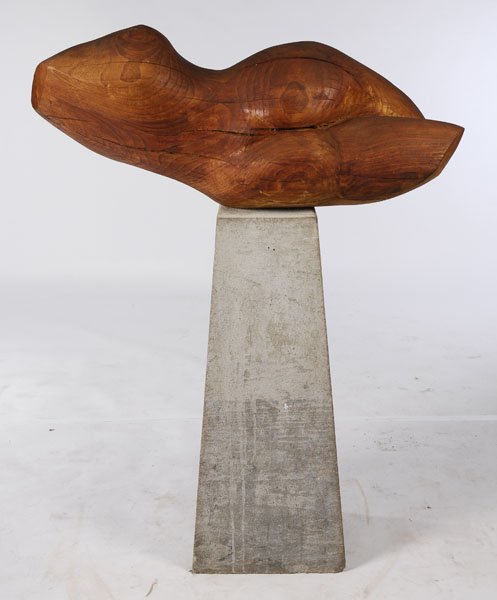 MODERNIST CARVED ELM FEMALE TORSO STONE PEDESTAL: A modernist carved elm female torso reclining on tapered cast stone pedestal, artist unknown. Width: 43" Depth: 16"