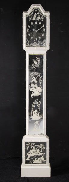 HOLLYWOOD FAUX BAMBOO PAINTED STANDING CLOCK: A Hollywood regency style faux bamboo painted standing clock having chinoiserie decorated inset mirrored paneled face and case circa 1970. Raised on stepped base. Ht: 79" Width: 14" Depth: 6"