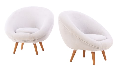 PAIR OF ROUNDED UPHOLSTERED LOUNGE CHAIRS ON WOODEN LEGS IN THE MANNER OF JEAN ROYERE.