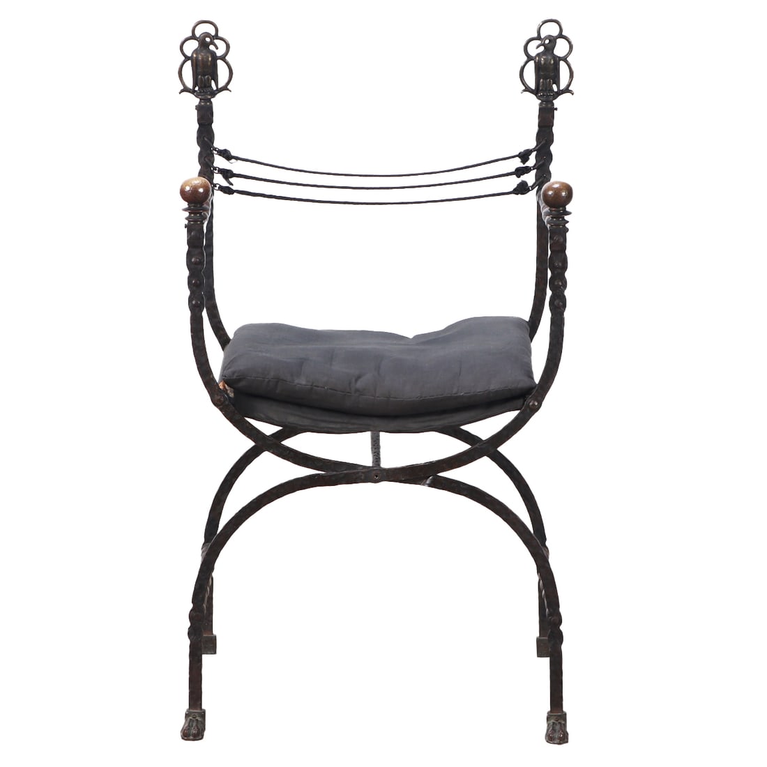 AN ANTIQUE WROUGHT IRON CURULE CHAIR IN THE MANNER OF OSCAR BACH HAVING BIRD FORM FINIALS CIRCA: An antique wrought iron curule chair in the manner of Oscar Bach having bird form finials circa 1910. Ht: 40.75" Wd: 24" Dpth: 15.75" Seat: 21"