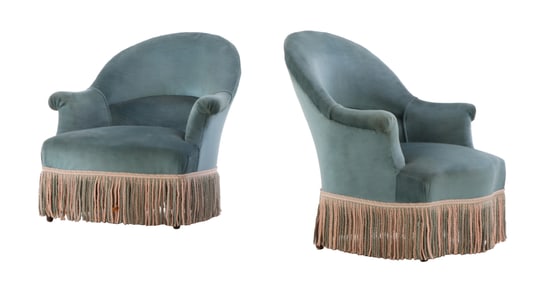 PAIR NINETEENTH CENTURY UPHOLSTERED LOUNGE CHAIRS RESTING ON EBONIZED TURNED LEGS WITH FRINGE