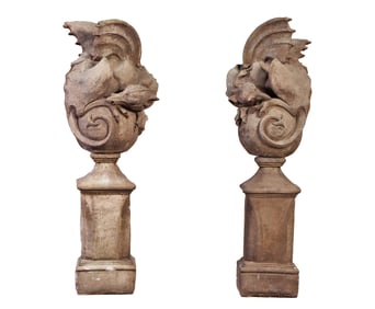 A PAIR OF CAST STONE WINGED GARGOYLES OR DRAGONS RAISED ON PEDESTAL BASES.