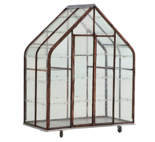 AN IRON AND GLASS GREENHOUSE MADE FROM RECYCLED MATERIALS.