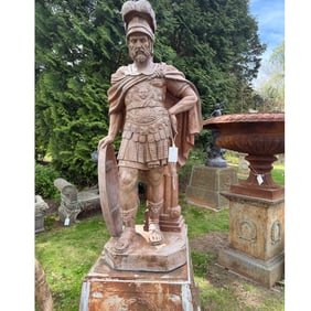 LIFESIZE CARVED MARBLE ROMAN WARRIOR HOLDING A SHIELD, ON CAST IRON BASE.