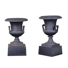TWO SIMILAR CAST IRON CAMPAGNA FORM GARDEN URNS WITH HANDLES.
