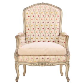 PAINTED FRENCH LOUIS XVI STYLE BERGERE CHAIR HAVING A NICELY CARVED FRAME AND FLORAL UPHOLSTERY
