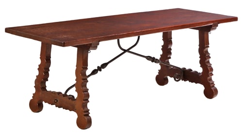 SPANISH STYLE OAK TABLE HAVING A GOUGED CARVED TOP AND AN IRON STRETCHER C 1940.