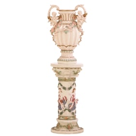 A LARGE RESIN TWIN HANDLED URN ON PEDESTAL IN THE ITALIAN CAPODIMONTE STYLE.